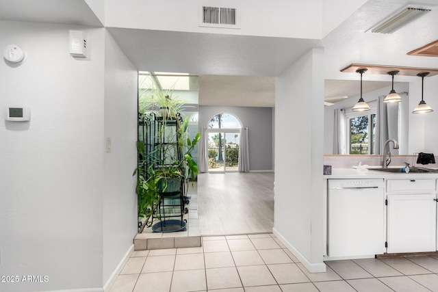 kitchen with dishwasher, visible vents, white cabinetry, and a sink