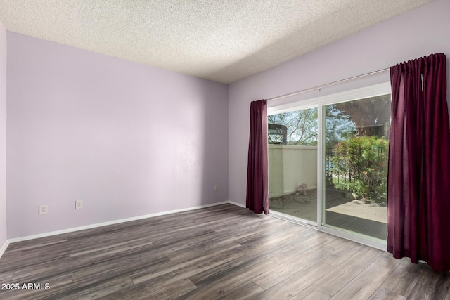 unfurnished room with wood finished floors, baseboards, and a textured ceiling