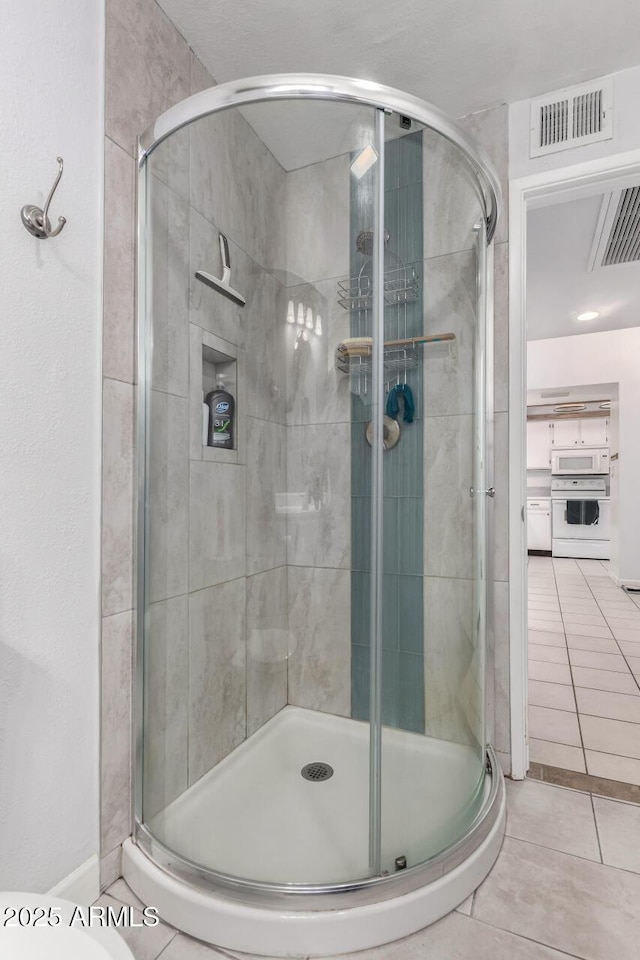 bathroom featuring tile patterned flooring, visible vents, and a shower stall