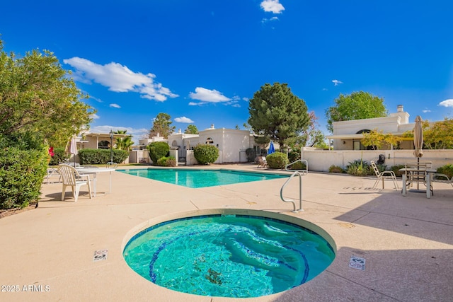 community pool featuring a patio, a community hot tub, and fence