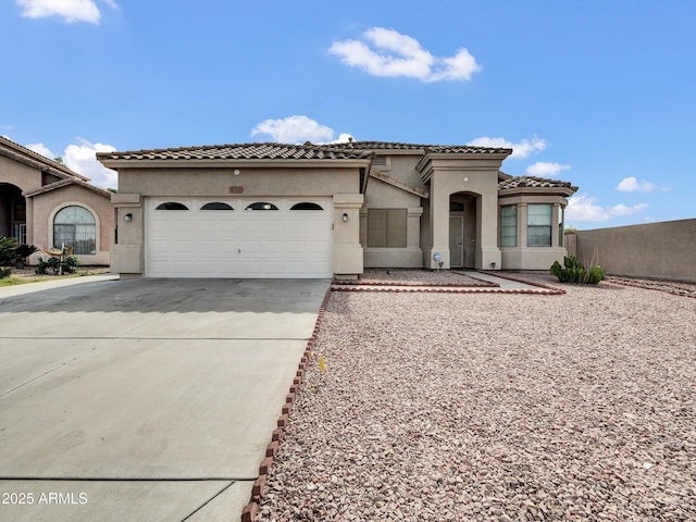 6752 W Citrus Way, Glendale, AZ 85303 - mediterranean / spanish-style house with driveway, a tiled roof, an attached garage, and stucco siding