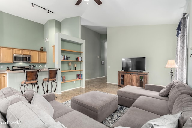 living room featuring high vaulted ceiling, rail lighting, and ceiling fan