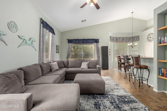 living room with ceiling fan with notable chandelier and vaulted ceiling