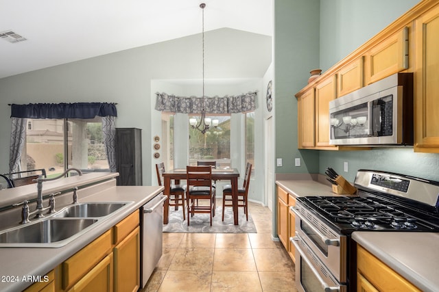 kitchen featuring a healthy amount of sunlight, vaulted ceiling, an inviting chandelier, pendant lighting, and appliances with stainless steel finishes