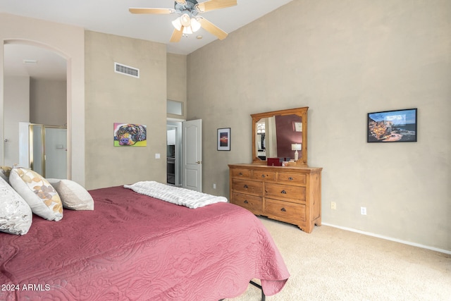 carpeted bedroom featuring a high ceiling and ceiling fan