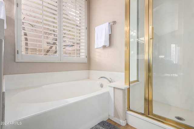 bathroom featuring shower with separate bathtub