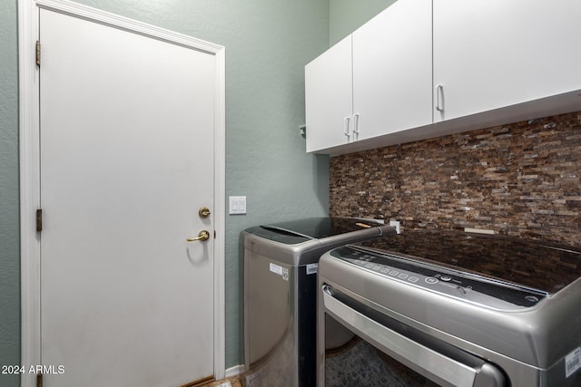 laundry room featuring cabinets and washing machine and dryer