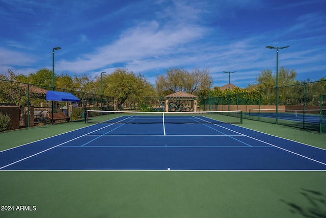 view of tennis court featuring basketball hoop