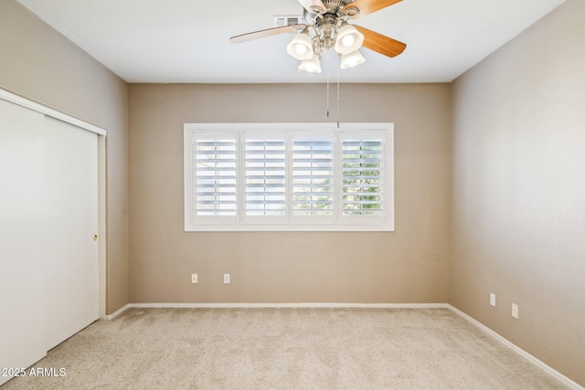 spare room with a ceiling fan and carpet