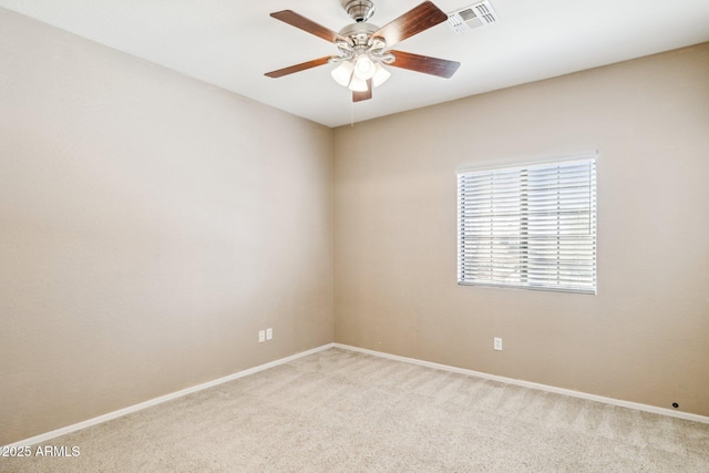 spare room featuring light colored carpet, visible vents, ceiling fan, and baseboards