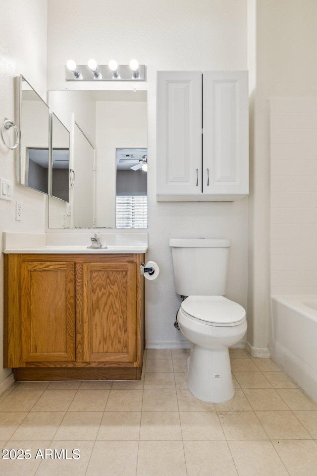 bathroom featuring a ceiling fan, toilet, a bathing tub, tile patterned floors, and vanity