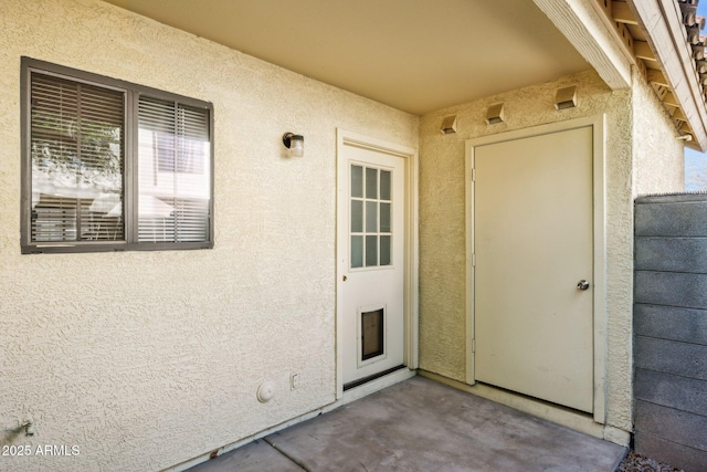 property entrance featuring stucco siding