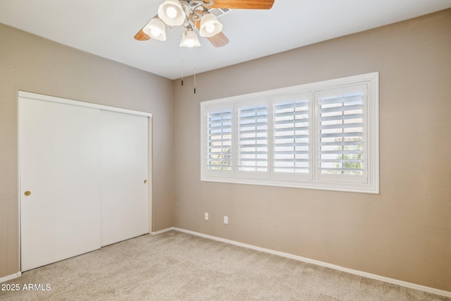 unfurnished bedroom featuring a ceiling fan, a closet, carpet flooring, and baseboards