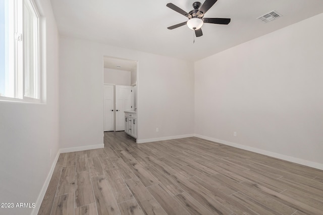 spare room with light wood-type flooring and ceiling fan