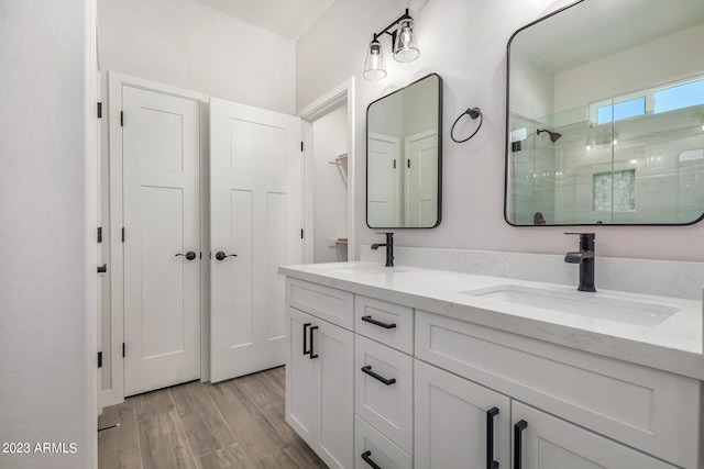 bathroom with wood-type flooring, vanity, and an enclosed shower