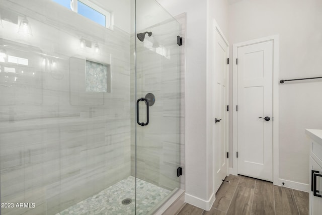 bathroom with walk in shower, hardwood / wood-style flooring, and vanity