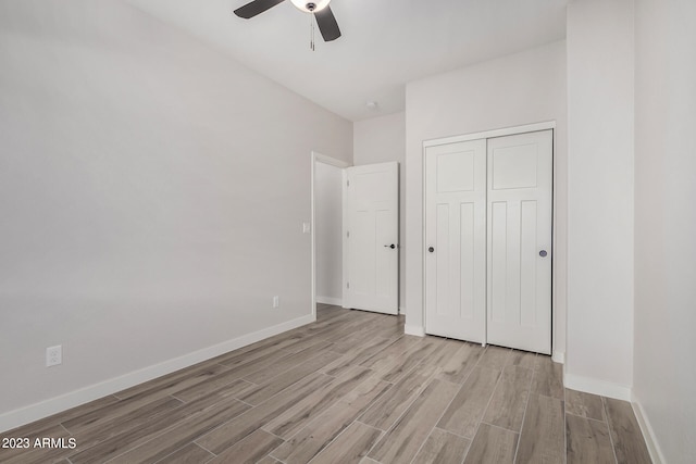 unfurnished bedroom featuring ceiling fan, light hardwood / wood-style flooring, and a closet