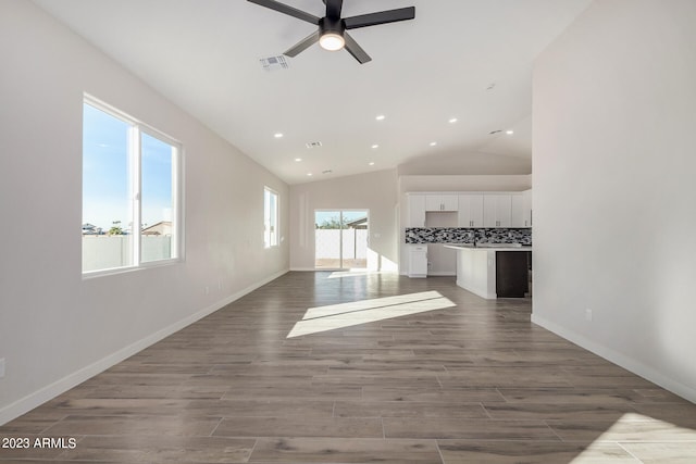 unfurnished living room with ceiling fan, hardwood / wood-style flooring, and vaulted ceiling