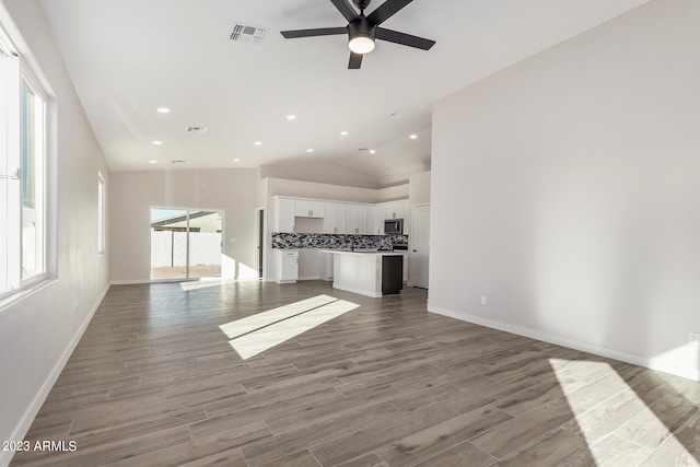 unfurnished living room featuring lofted ceiling, ceiling fan, and light hardwood / wood-style flooring