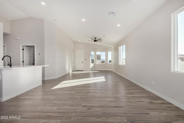 unfurnished living room featuring light hardwood / wood-style floors, ceiling fan, and a healthy amount of sunlight