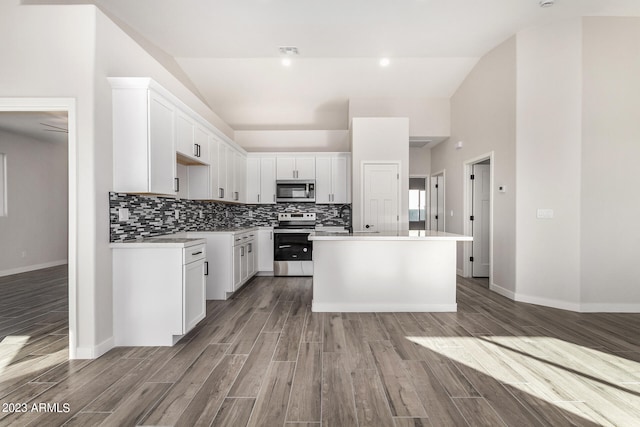 kitchen featuring appliances with stainless steel finishes, a center island with sink, light hardwood / wood-style floors, and white cabinets