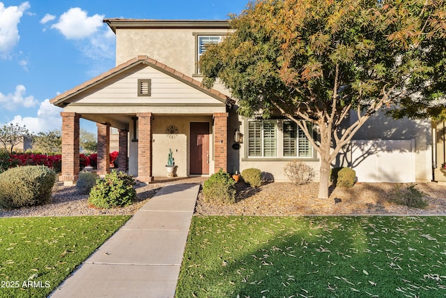 view of front of house featuring a garage, a front yard, and covered porch