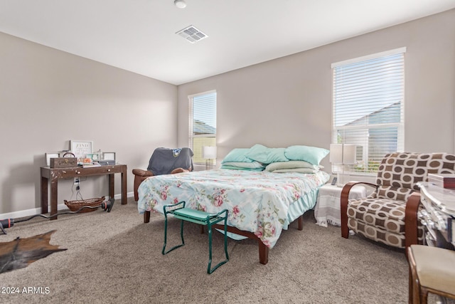 carpeted bedroom featuring multiple windows, visible vents, and baseboards