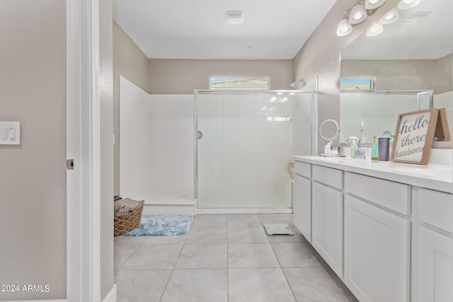 bathroom with tile patterned floors, vanity, and walk in shower