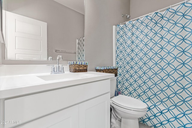bathroom featuring toilet, vanity, and curtained shower