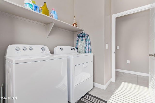 washroom featuring independent washer and dryer, light tile patterned flooring, and baseboards