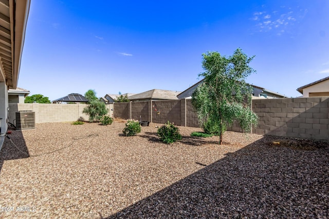 view of yard with a fenced backyard and central air condition unit