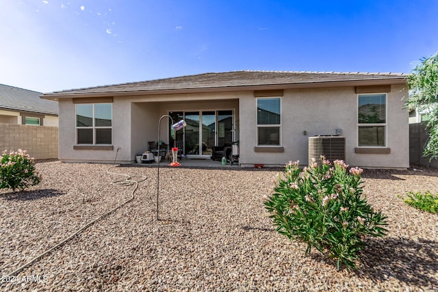 rear view of property with stucco siding, fence, cooling unit, and a patio