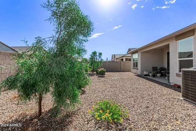 view of yard featuring a fenced backyard, central AC unit, and a patio