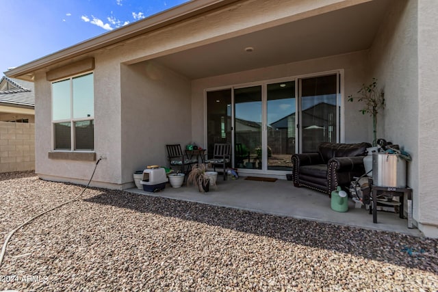 back of property with fence, stucco siding, and a patio