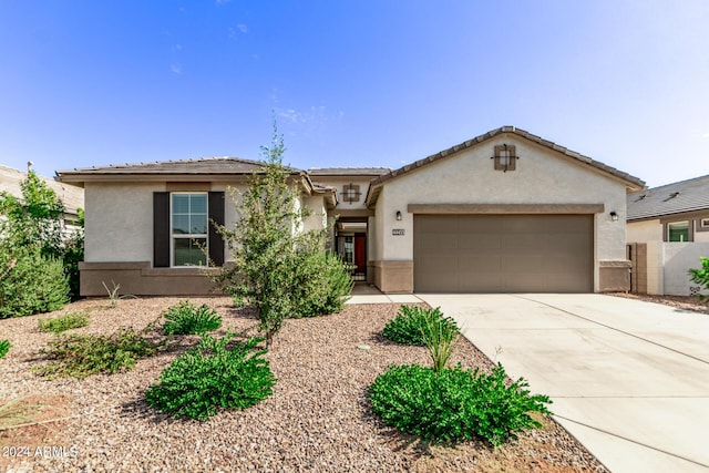 view of front facade featuring stucco siding, an attached garage, a tile roof, and concrete driveway