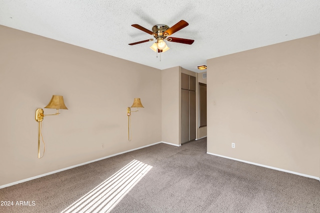 carpeted spare room with a textured ceiling and ceiling fan