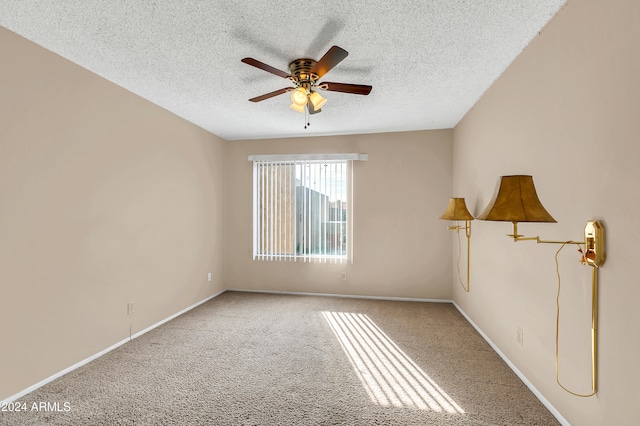 spare room with ceiling fan, light colored carpet, and a textured ceiling