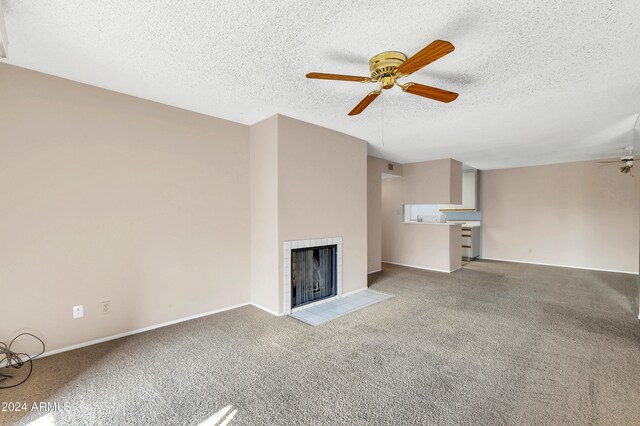 unfurnished living room featuring ceiling fan, light colored carpet, and a fireplace