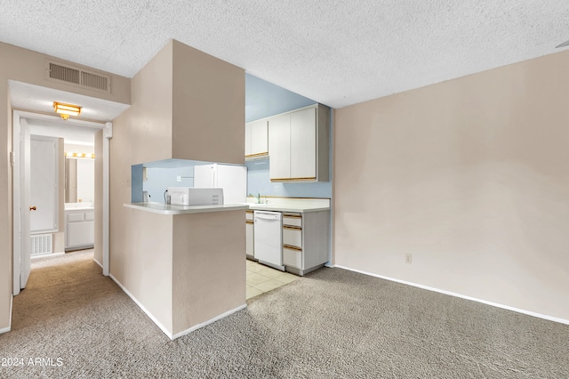 kitchen with white cabinets, light colored carpet, a textured ceiling, and kitchen peninsula