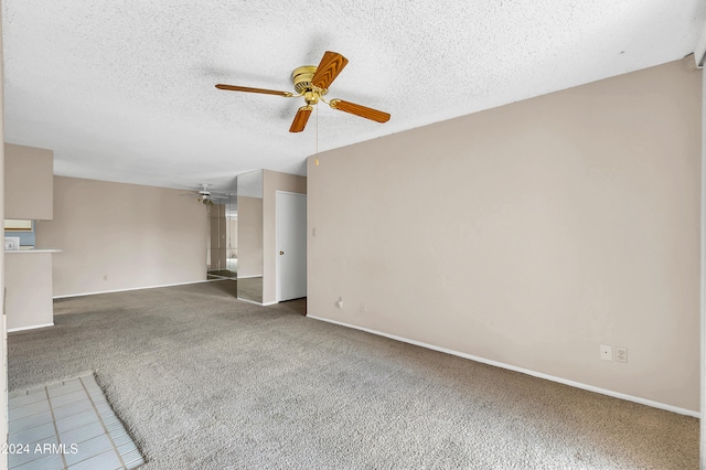 unfurnished living room with ceiling fan, a textured ceiling, and carpet floors