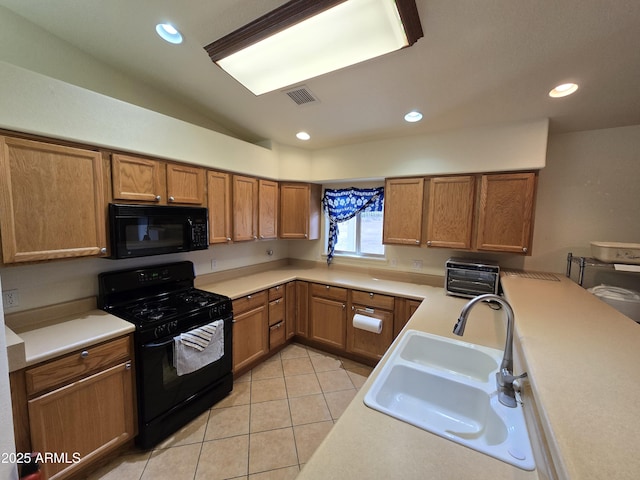 kitchen featuring light tile patterned floors, sink, vaulted ceiling, and black appliances