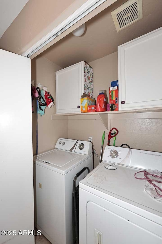 laundry room featuring cabinet space, visible vents, and washer and dryer