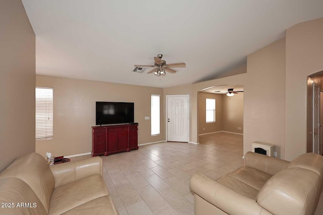 living room with visible vents, arched walkways, ceiling fan, and light tile patterned floors