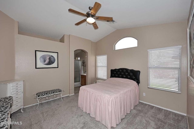 bedroom with vaulted ceiling, baseboards, arched walkways, visible vents, and light carpet