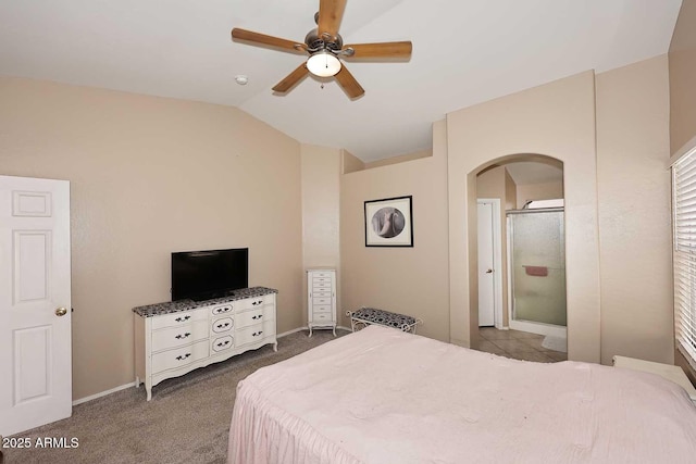 carpeted bedroom with vaulted ceiling, arched walkways, ensuite bathroom, and a ceiling fan