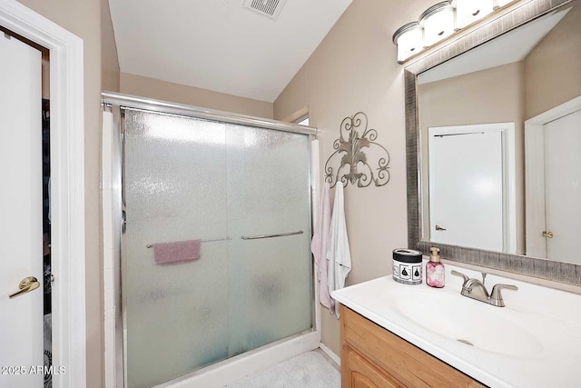 full bathroom with vanity, a shower stall, and visible vents