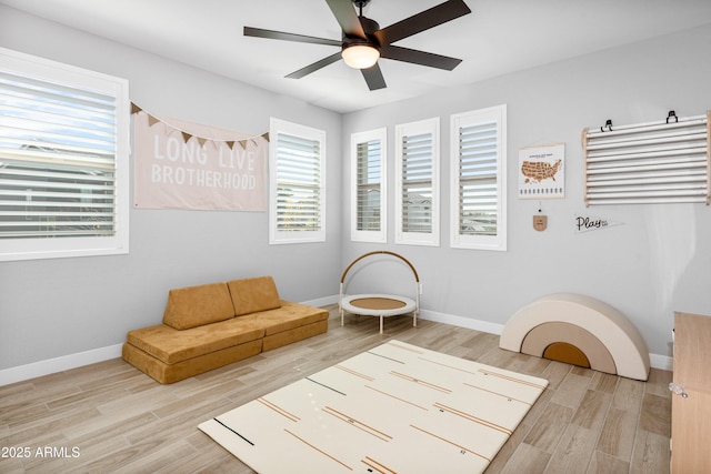 living area with ceiling fan and light wood-type flooring