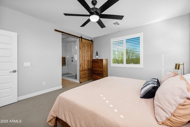 bedroom featuring ceiling fan, light colored carpet, connected bathroom, and a barn door