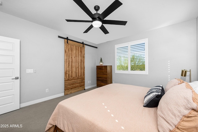 carpeted bedroom with a barn door and ceiling fan