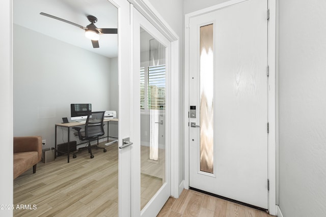 doorway with french doors, ceiling fan, and light wood-type flooring